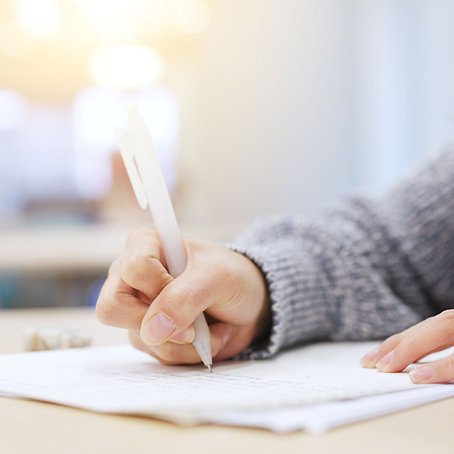 Student writing on paper